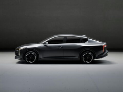 "A sleek modern car on a scenic road, showcasing electric vehicle technology, futuristic design, and automotive innovation in high resolution"